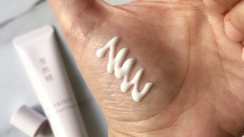 雪肌精クリアウェルネスのモイストリペアクリームを手に出しています。