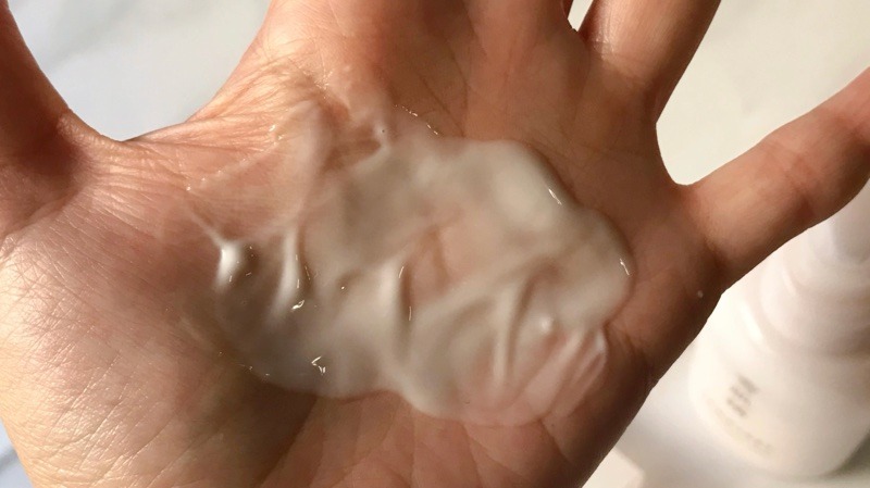 雪肌精クリアウェルネス モイストリペアミルクを肌に伸ばしてテクスチャーを見せています。
